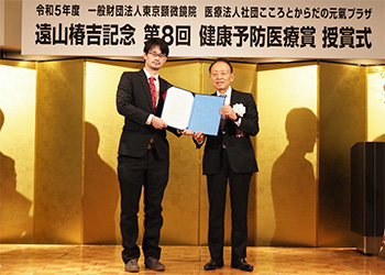 「日本での新型コロナウイルス感染症と血栓症を調査するタスクフォース」代表の山下侑吾氏(左)に授与。右は当法人・医療法人の山田匡通理事長